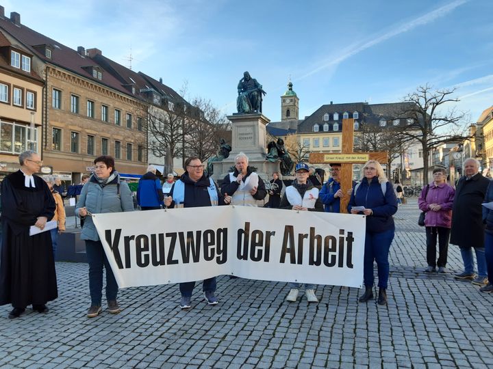 Teilnehmerinnen und Teilnehmer am Kreuzweg der Arbeit auf dem Marktplatz.
