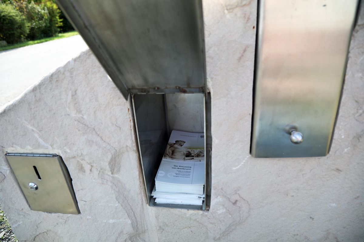 In einem Steinblock bei der ersten Station findet man Faltblätter mit Informationen zum Kreuzweg.