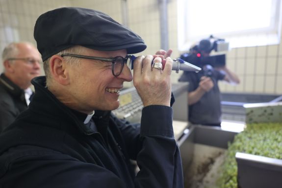 Bischof Dr. Franz Jung prüft mit dem Refraktometer das Mostgewicht. 