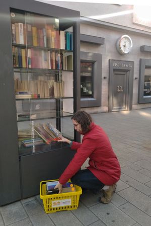 Anne Große-Schulte, Leiterin der Würzburger Liborius-Wagner-Bücherei, stellt einen Teil der Bücher, die sonst beim jährlichen Flohmarkt verkauft werden, in den öffentlichen Bücherschrank in der Eichhornstraße ein. 