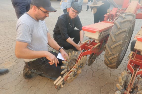 Von Christian Regnet (links) ließ sich Bischof Dr. Franz Jung erklären, wie die moderne Sämaschine einzelne Samenkörner in den Boden einbringt. 