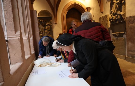 Zahlreiche Gottesdienstbesucher unterzeichneten im Domkreuzgang nach dem Gottesdienst den "neuen Katakombenpakt".  Zahlreiche Gottesdienstbesucher unterzeichneten im Domkreuzgang nach dem Gottesdienst den "neuen Katakombenpakt".