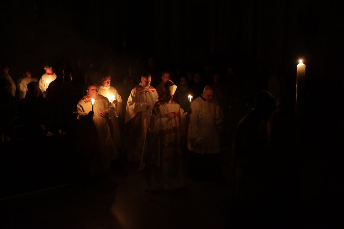 Danach wurde das Osterlicht in Begleitung von Mitgliedern des Domkapitels in den dunklen Kiliansdom getragen und an die Gläubigen weitergereicht.
