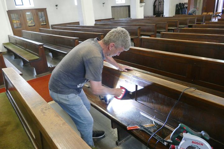 Vereinsmitglied Günter Berninger zersägt eine Kirchenbank.
