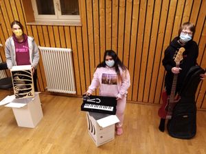 Die Teilnehmerinnen Jasmin Greller, Saba Hussein und Svenja Zösch freuen sich über die Spende des "New Future"-Chors und die neuen Musikinstrumente. 
