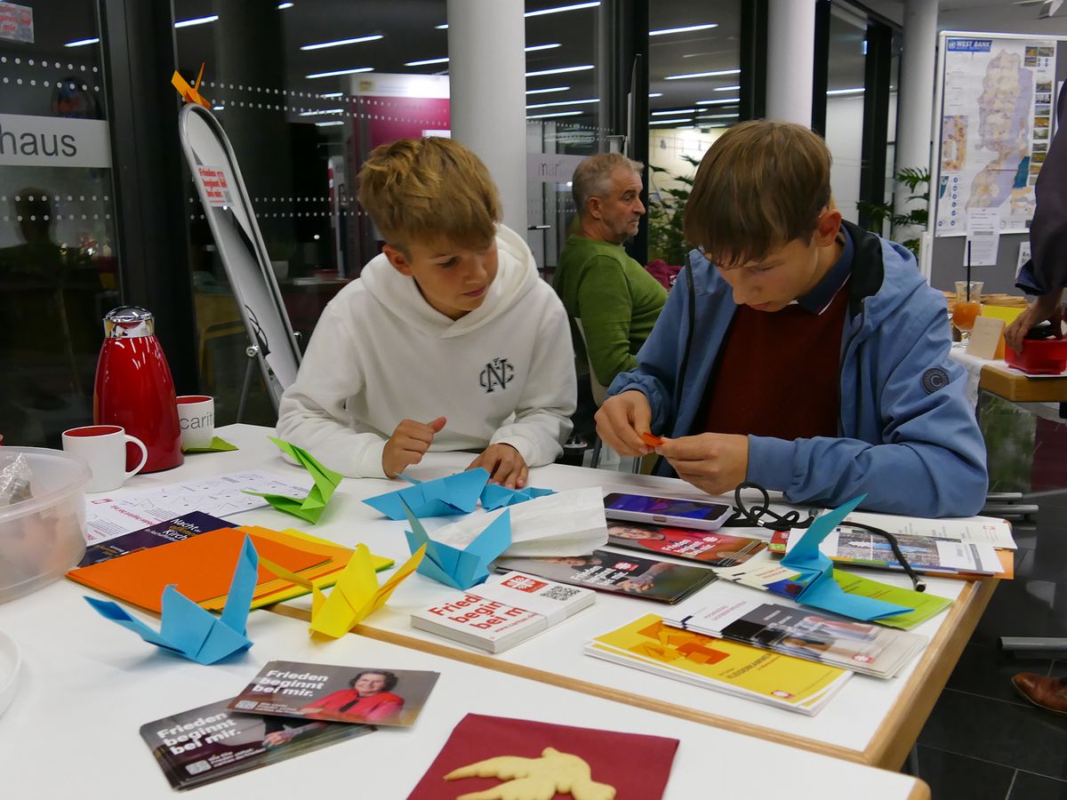 Friedenstauben basteln die beiden jungen Männer am Stand der Caritas im Martinushaus. Friedenstauben basteln die beiden jungen Männer am Stand der Caritas im Martinushaus.