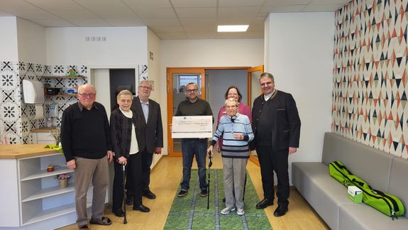 Domkapitular Monsignore Clemens Bieber, Vorsitzender des Diözesan-Caritasverbands Würzburg, (rechts) und Bastian Graber (mit Scheck), Direktor des Caritas-Kurhauses Bad Bocklet, überreichten die Spende an Gäste und Mitarbeiter der Tagespflege Kleinheubach.