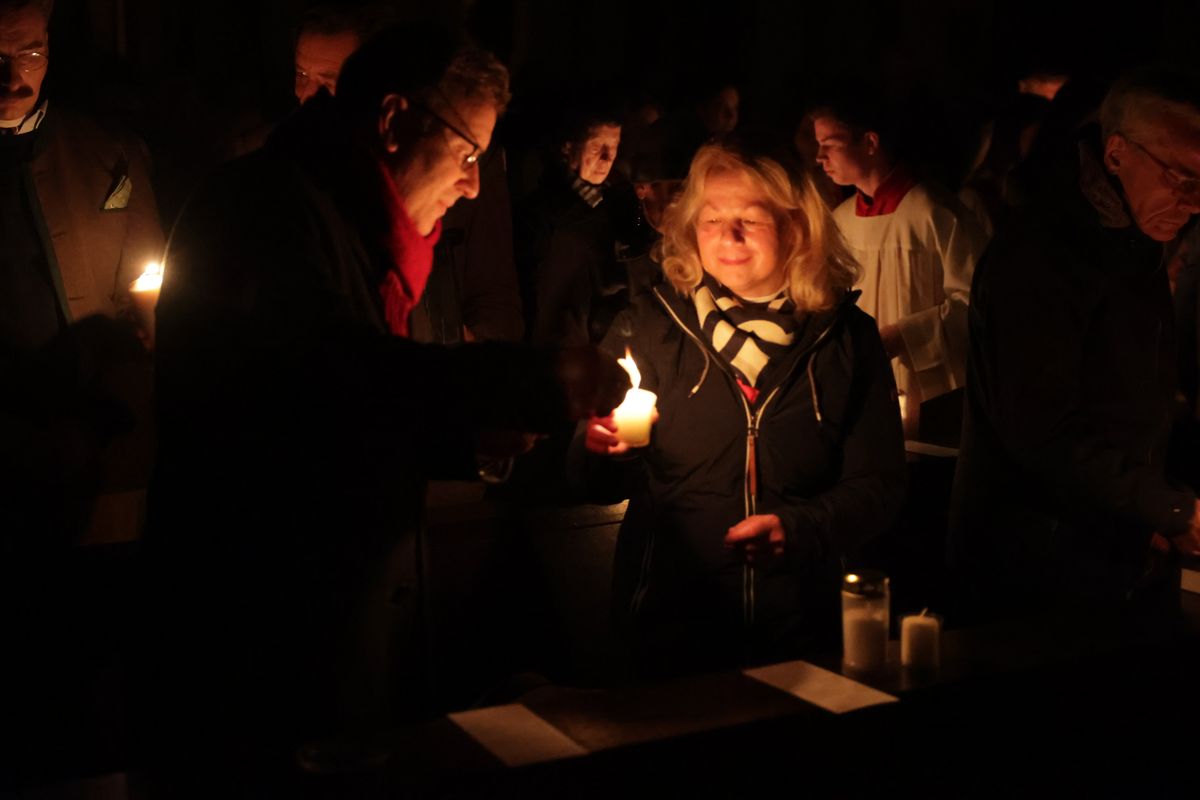 Danach wurde das Osterlicht in Begleitung von Mitgliedern des Domkapitels in den dunklen Kiliansdom getragen und an die Gläubigen weitergereicht.