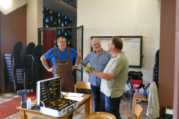 Die Vereinsvorstände Robert Flörchinger und Peter Müller besprechen mit Zimmermann Kilian Grimm das Vorgehen bei der Bankaktion.