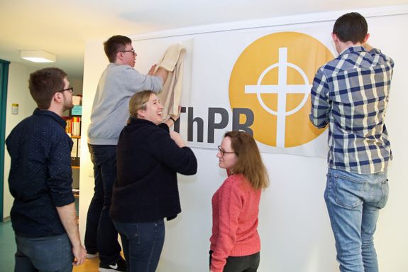 Im Zentrum für Theologiestudierende und zukünftige Pastoralreferentinnen und -referenten (ZThPR) im Kilianeum-Haus der Jugend in Würzburg gibt es das Logo nun als Wandtattoo. Beim Kleben (von links): Christoph Schuhmann, Fabian Waldherr, Pastoralreferentin Andrea Schoknecht, Ausbildungsleiterin für die erste Bildungsphase, Lea Brenner und Gabriel Abb.