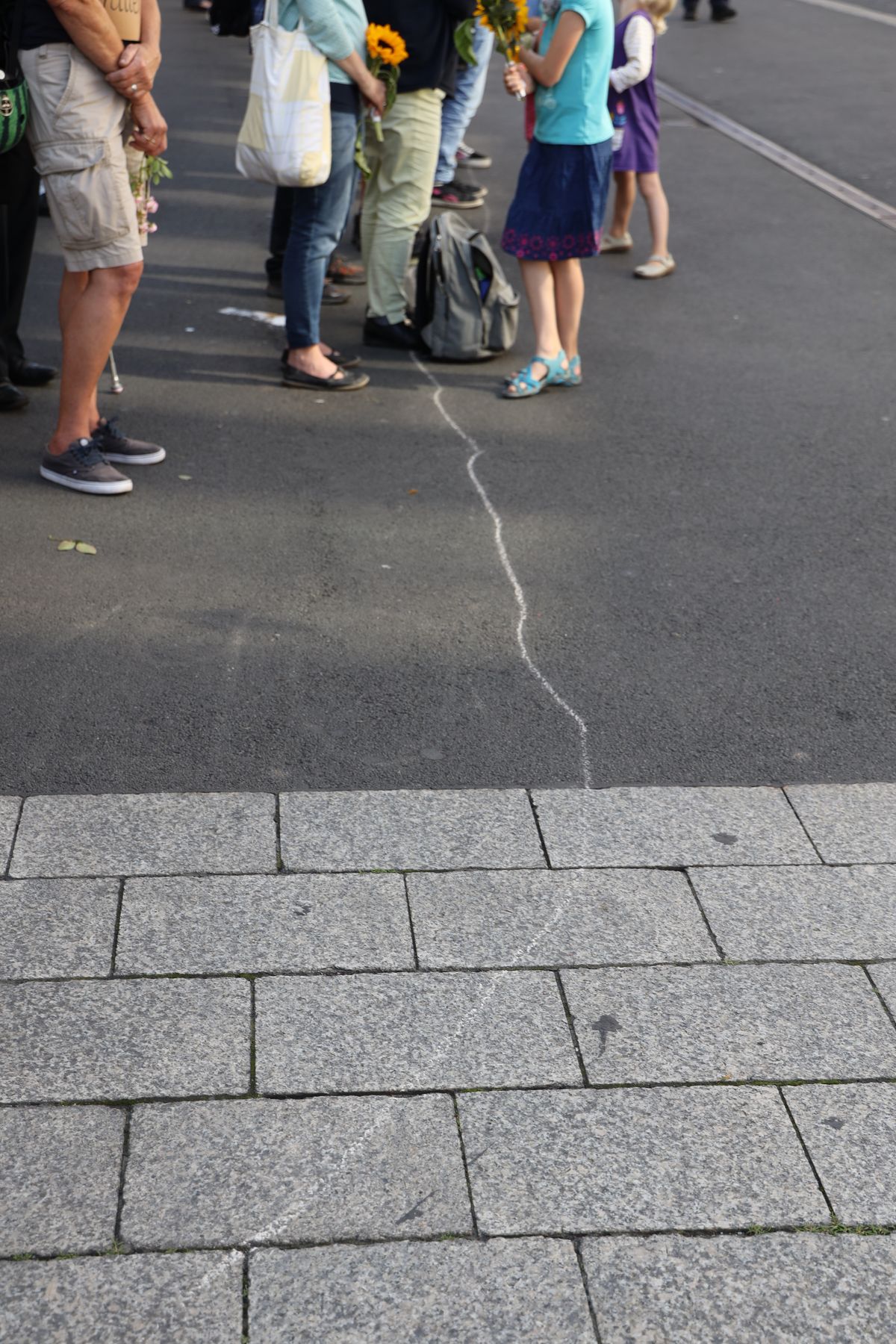 2721/0652 Menschenkette_28502 Unter dem Titel "Würzburg trauert" fand am Freitagabend eine Menschenkette vom Barbarossaplatz zum Würzburger Rathaus statt. Die Veranstalter hatten mit Kreide eine Linie auf dem Boden markiert, damit die Teilnehmer sich für die Aufstellung orientieren konnten.