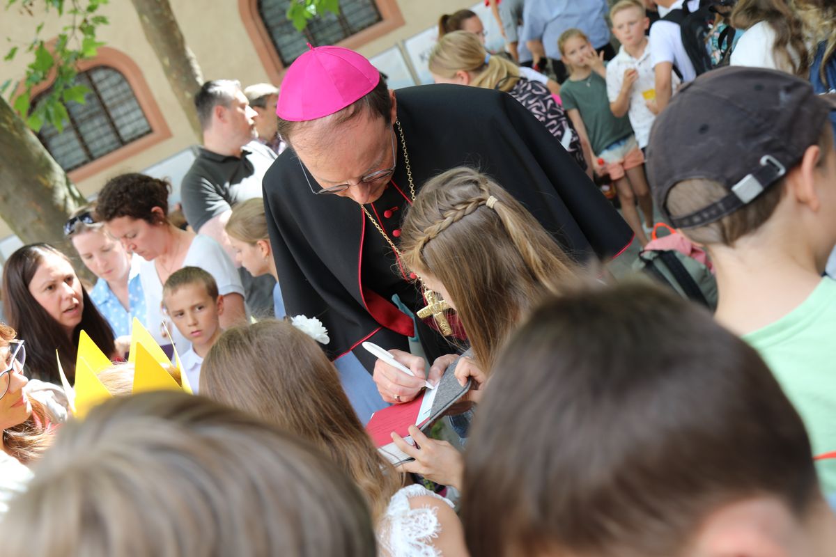 Mit rund 1300 Kommunionkindern und ihren Begleitern hat Weihbischof Paul Reder am Montag, 8. Juli, einen Gottesdienst im Kiliansdom gefeiert. Nach dem Gottesdienst beantwortete er auf dem Kiliansplatz die Fragen der Kinder und gab Autogramme.