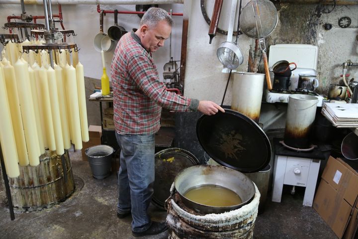 Martin Schenk öffnet den Behälter mit dem härteren Wachs. Über die Kerzen gezogen, sorgt es dafür, dass sie nicht tropfen.