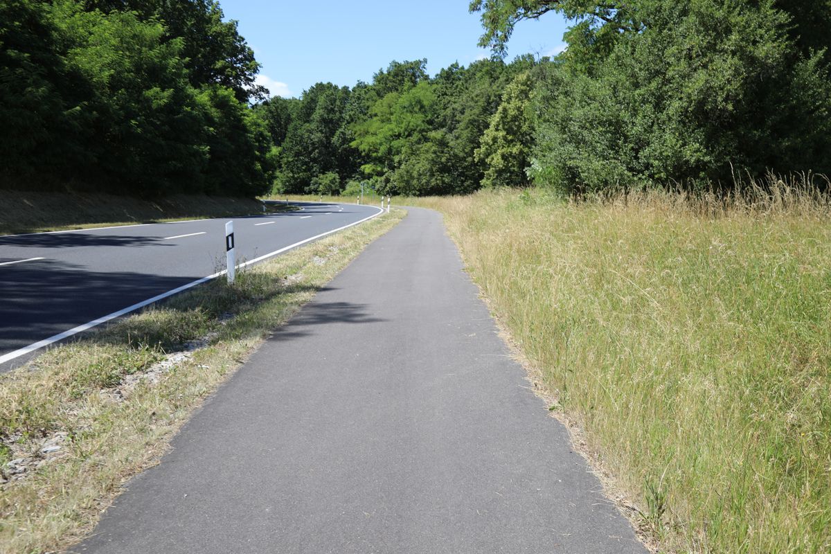 Auf einem geteerten Fußweg folgt ein Teil der Strecke bergauf der Straße in Richtung Rütschenhausen.