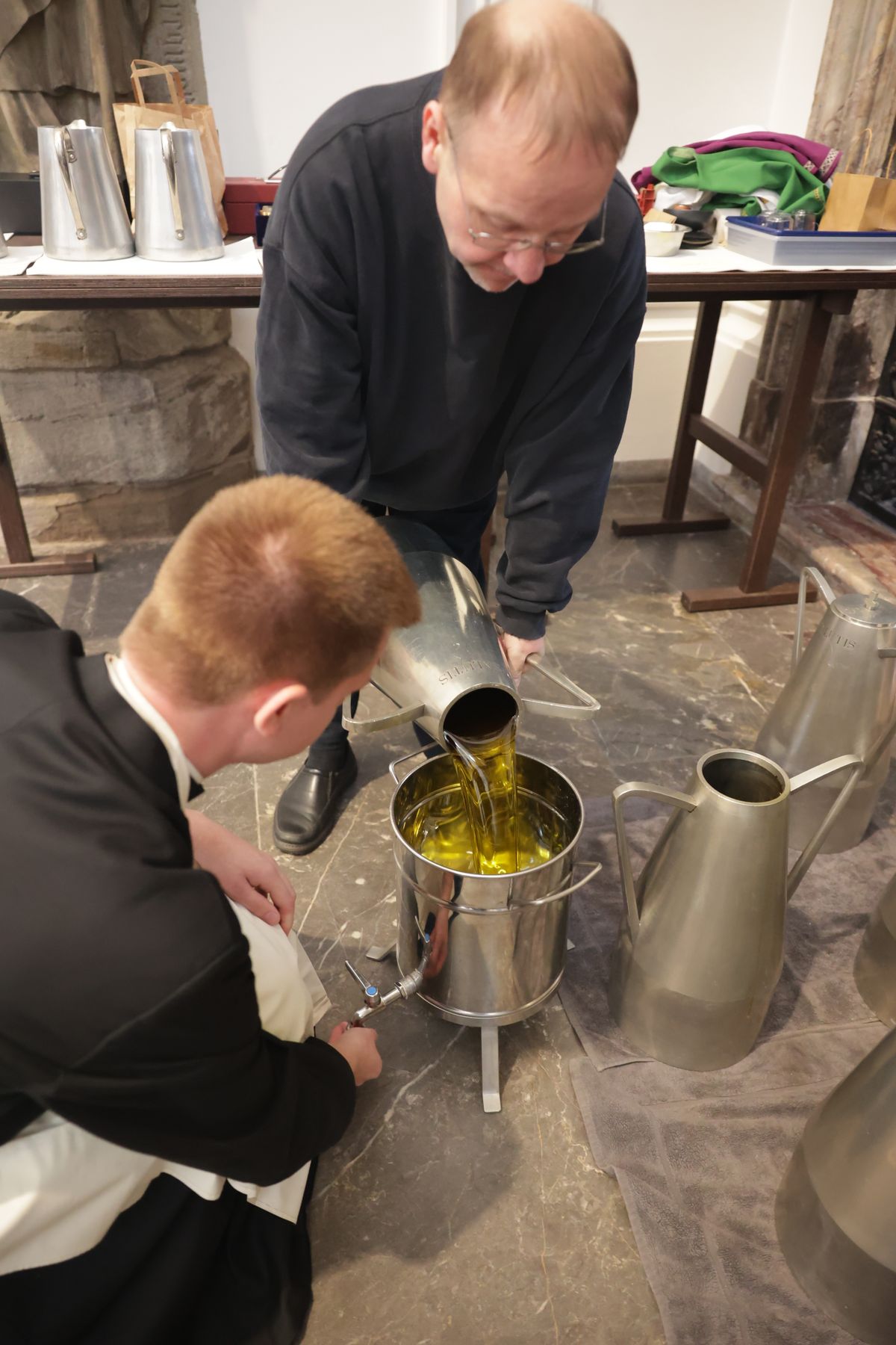 Dommesner Thomas Schumann füllt die Heiligen Öle aus den Kannen in Behälter, aus denen diese dann weiterverteilt werden.  Dommesner Thomas Schumann füllt die Heiligen Öle aus den Kannen in Behälter, aus denen diese dann weiterverteilt werden.