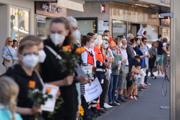 2721/0652 Menschenkette_28500 Zahlreiche Menschen nahmen an der Aktion "Würzburg trauert" teil. Viele trugen Schilder mit der Aufschrift "Würzburg trauert" und "Würzburg hält zusammen" oder Blumen in den Händen.