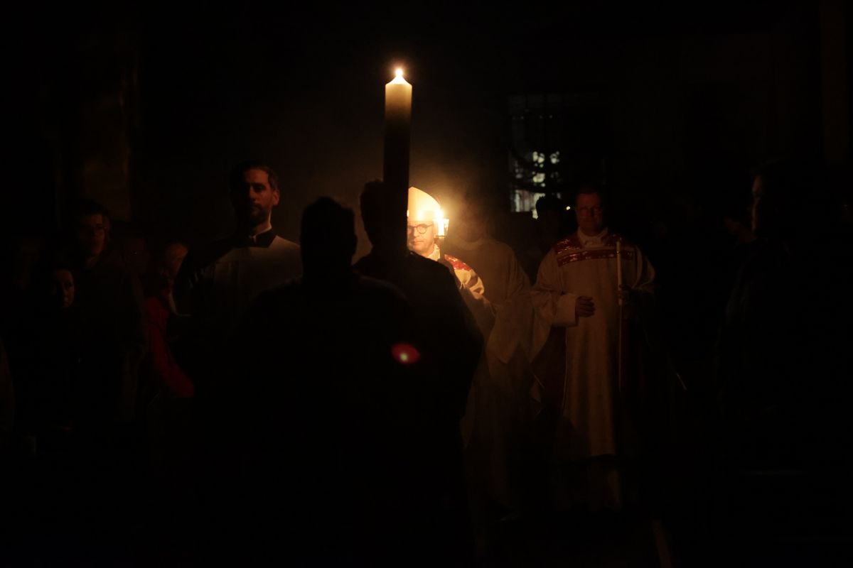 Danach wurde das Osterlicht in Begleitung von Mitgliedern des Domkapitels in den dunklen Kiliansdom getragen und an die Gläubigen weitergereicht.