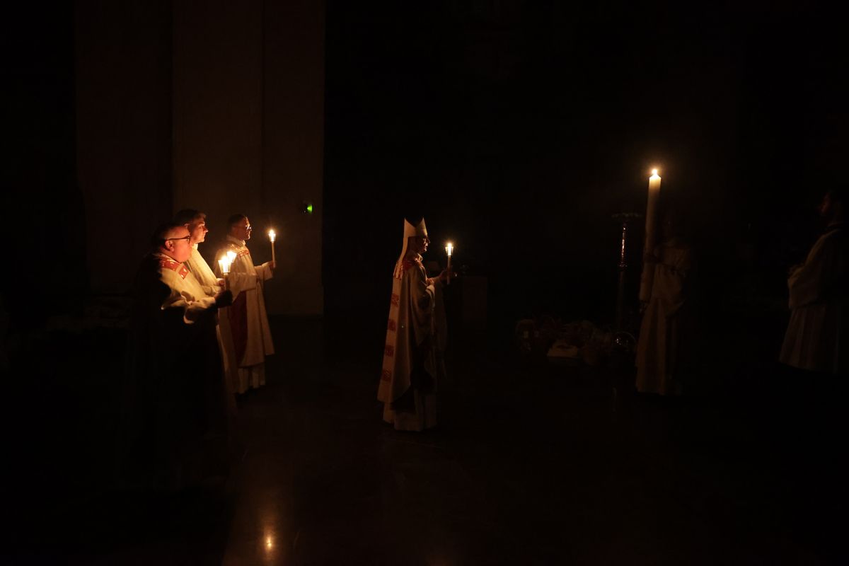 Danach wurde das Osterlicht in Begleitung von Mitgliedern des Domkapitels in den dunklen Kiliansdom getragen und an die Gläubigen weitergereicht.