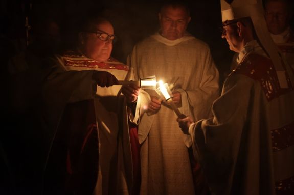 Danach wurde das Osterlicht in Begleitung von Mitgliedern des Domkapitels in den dunklen Kiliansdom getragen und an die Gläubigen weitergereicht.