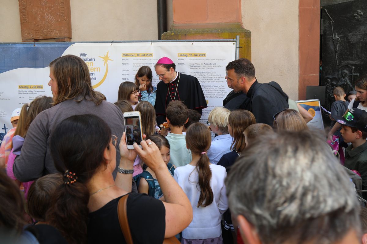 Mit rund 1300 Kommunionkindern und ihren Begleitern hat Weihbischof Paul Reder am Montag, 8. Juli, einen Gottesdienst im Kiliansdom gefeiert. Nach dem Gottesdienst beantwortete er auf dem Kiliansplatz die Fragen der Kinder und gab Autogramme.