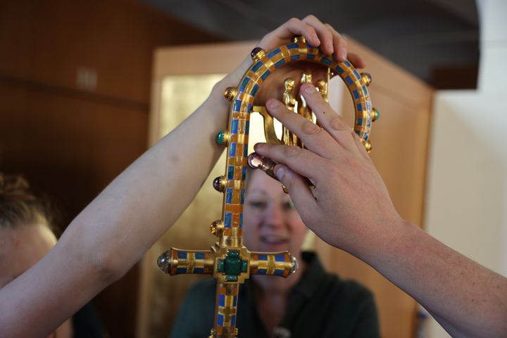 Alexandra Eck, Referentin für Dombesucherpastoral, hält den Kiliansstab Menschen mit Sehbehinderung zum Ertasten hin. 