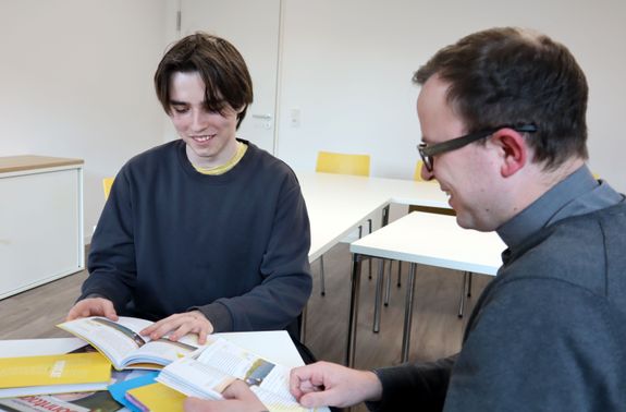 Noah Wirsching (links) und Pfarrvikar Bertram Ziegler im Gemeindezentrum Sankt Andreas bei der Vorbereitung auf die Taufe.