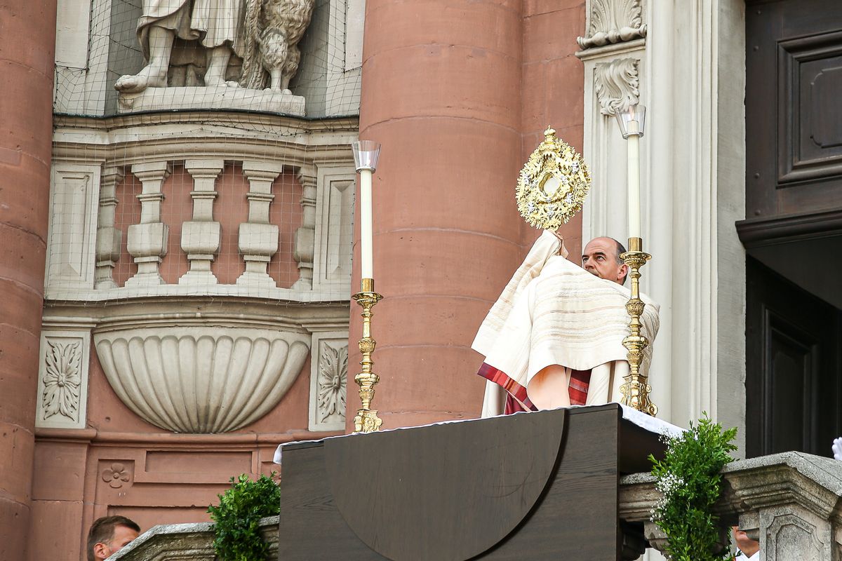 Bei der Fronleichnamsprozession in Würzburg erteilt Bischof Dr. Franz Jung auf der Treppenanlage des Neumünsters den eucharistischen Segen mit der Monstranz.