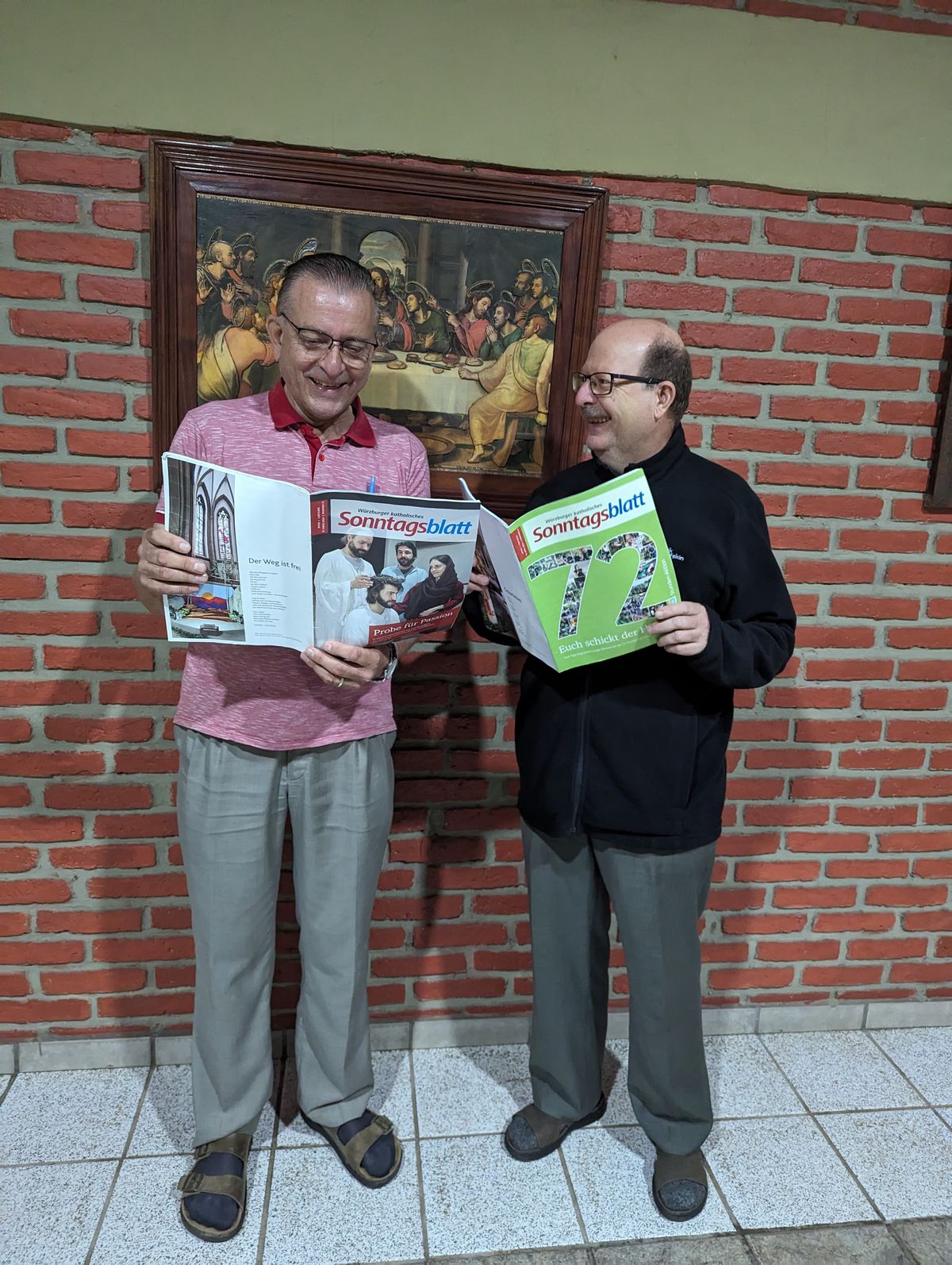 Pfarrer Thomas Hermes (links) und Pfarrer Christian Müssig mit jeweils einer Ausgabe des Würzburger katholischen Sonntagsblatts.