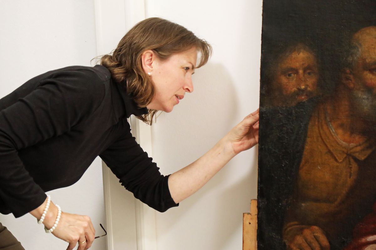 Restauratorin Gudrun Hanika prüft, wie Bild und Rahmen miteinander verbunden sind.