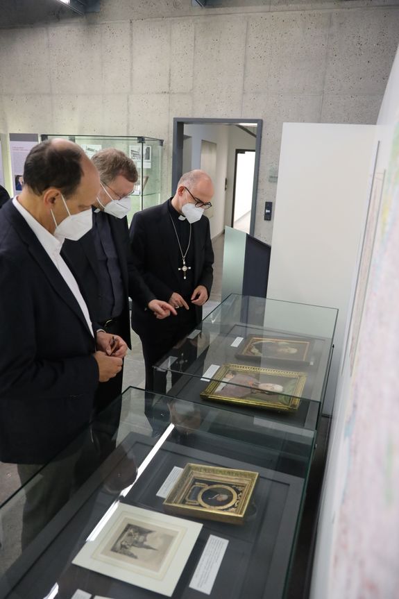Thomas Wehner erklärt Generalvikar Dr. Jürgen Vorndran und Bischof Dr. Franz Jung (von links) einige der Exponate der Ausstellung.